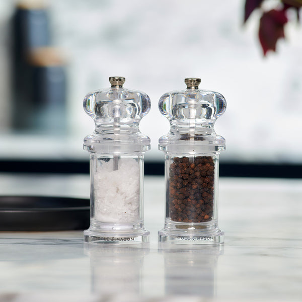 #salt
Two Cole & Mason 505 Salt & Pepper Mills, each with adjustable settings and durable grinding mechanisms, stand side by side on a marble countertop. One holds white salt crystals, the other black peppercorns; the background is softly blurred.