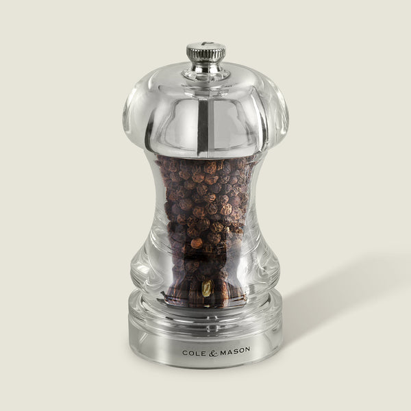 #115mm#pepper
The Cole & Mason Acrylic Capstan Pepper Mill, from the Acrylic Capstan Salt & Pepper Mills range, features a clear acrylic body, metallic top knob, quality grinder, and branding on the base. Filled with whole black peppercorns and set against a light background.