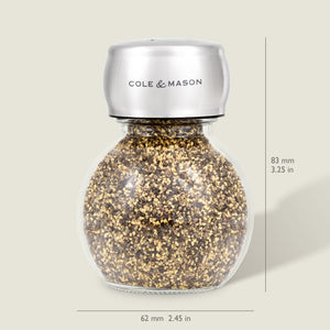 The Darlington Shakers Set by Cole & Mason features a glass and stainless steel spice grinder for seasoning control, filled with pepper granules, measuring 83 mm tall by 62 mm wide; Cole & Mason is labeled on the top. Dimensions shown right and bottom.