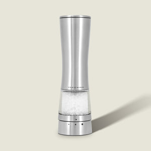 A Cole & Mason Electric Derwent Salt & Pepper Mill, crafted from stainless steel with a transparent base filled with coarse salt, stands upright on a light beige background.