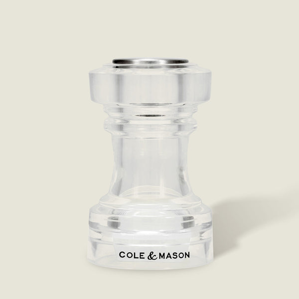 This simple, modern Acrylic Salt Shaker & Pepper Mill Set (104 mm) by Cole & Mason features a clear acrylic adjustable grinder, with the brand name displayed in black on the base against a light beige background.