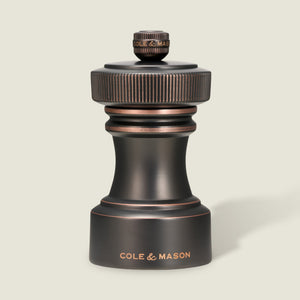 Set against a light background, the Hoxton Salt and Pepper Mill Set in antique bronze from Cole & Mason showcases refined craftsmanship, with “COLE & MASON” engraved on the base. Elegantly presented in a gift box, this striking set is a sophisticated addition to any table.